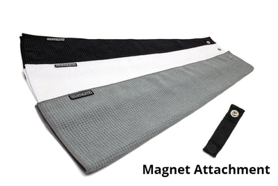 A set of three magnetic golf towels by Clothlete in white, gray, and black. Each waffle-weave microfiber golf towel comes with a magnetic attachment at the top edge.