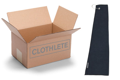 Cardboard box of bulk golf towels with grommets and hooks, containing 100 microfiber towels. Black waffle weave microfiber golf towels come in an asymmetrical design.
